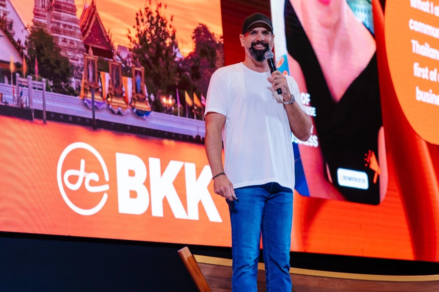 Speaker addressing an audience on stage at a corporate conference