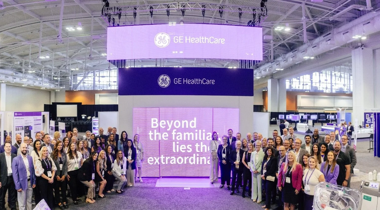 Wide panoramic view of a large Nashville conference exhibit hall filled with attendees and branded booths