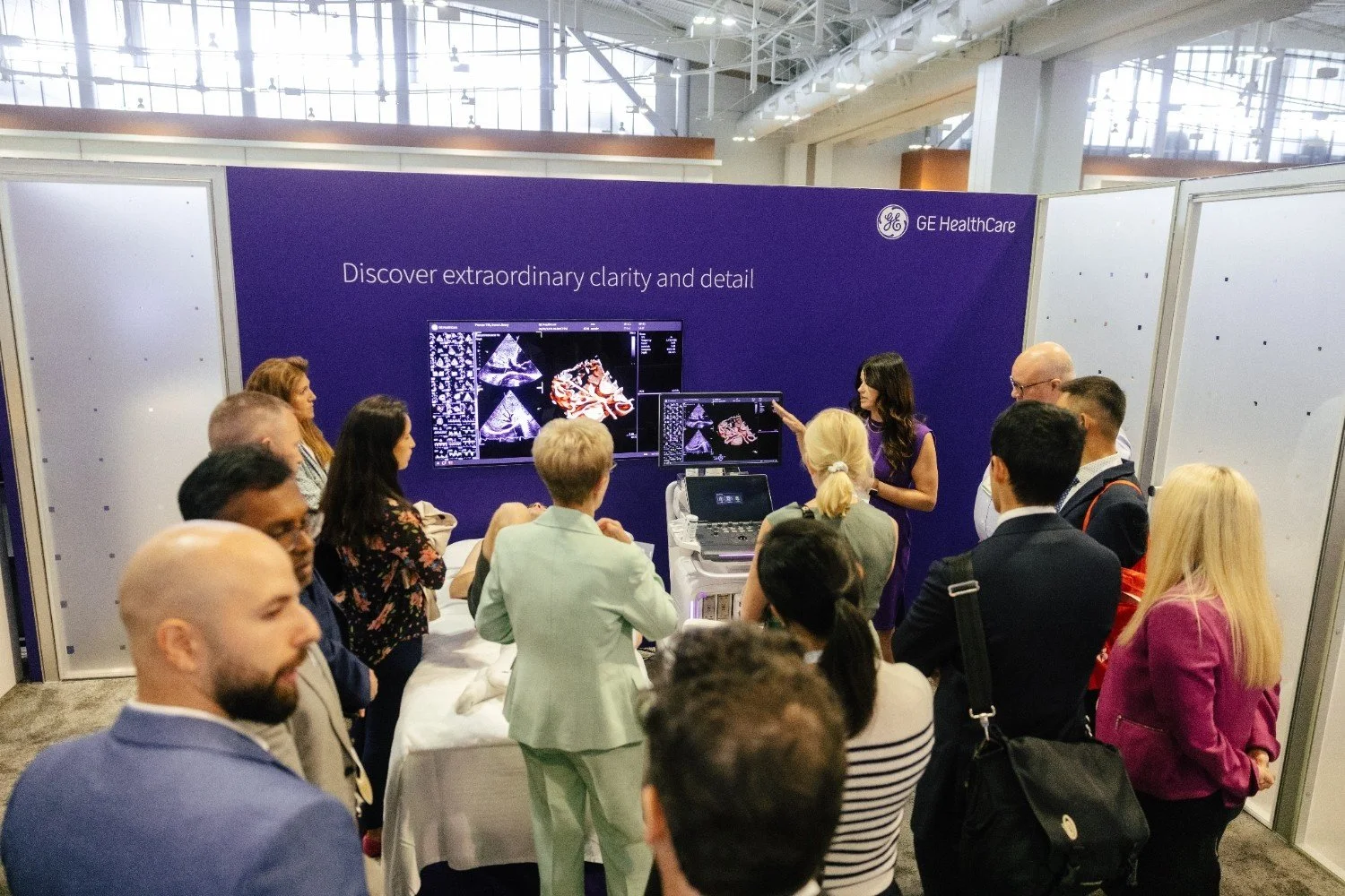 Conference attendees gathered around a large branded exhibit booth display
