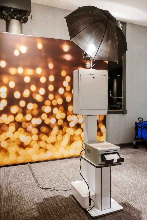 Headshot booth kiosk with umbrella lighting set up against a glittering bokeh backdrop