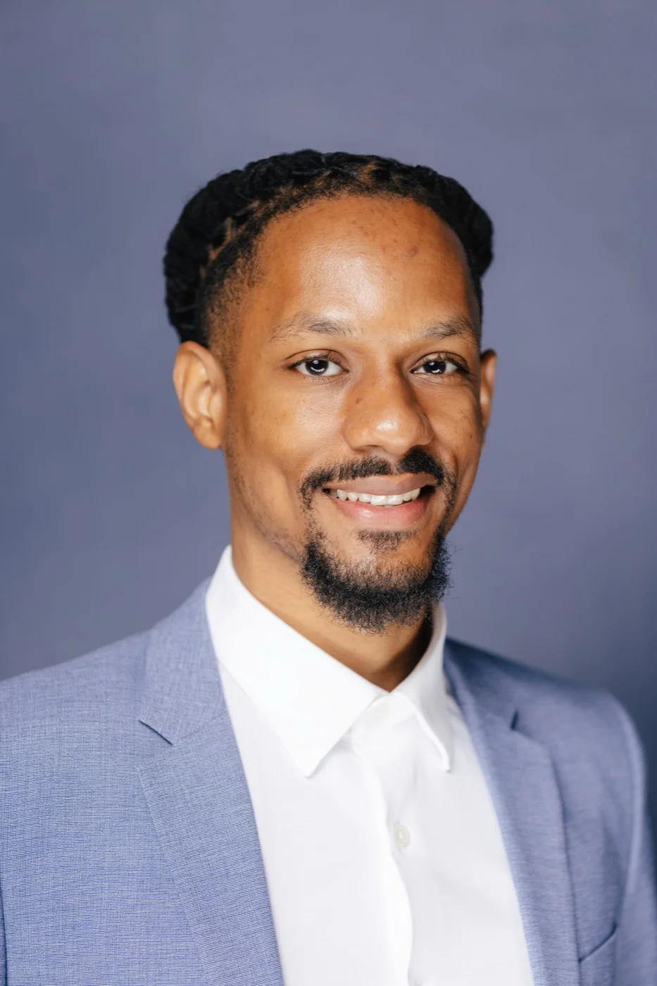 Smiling businessman in a light blue blazer during a personal branding headshot session