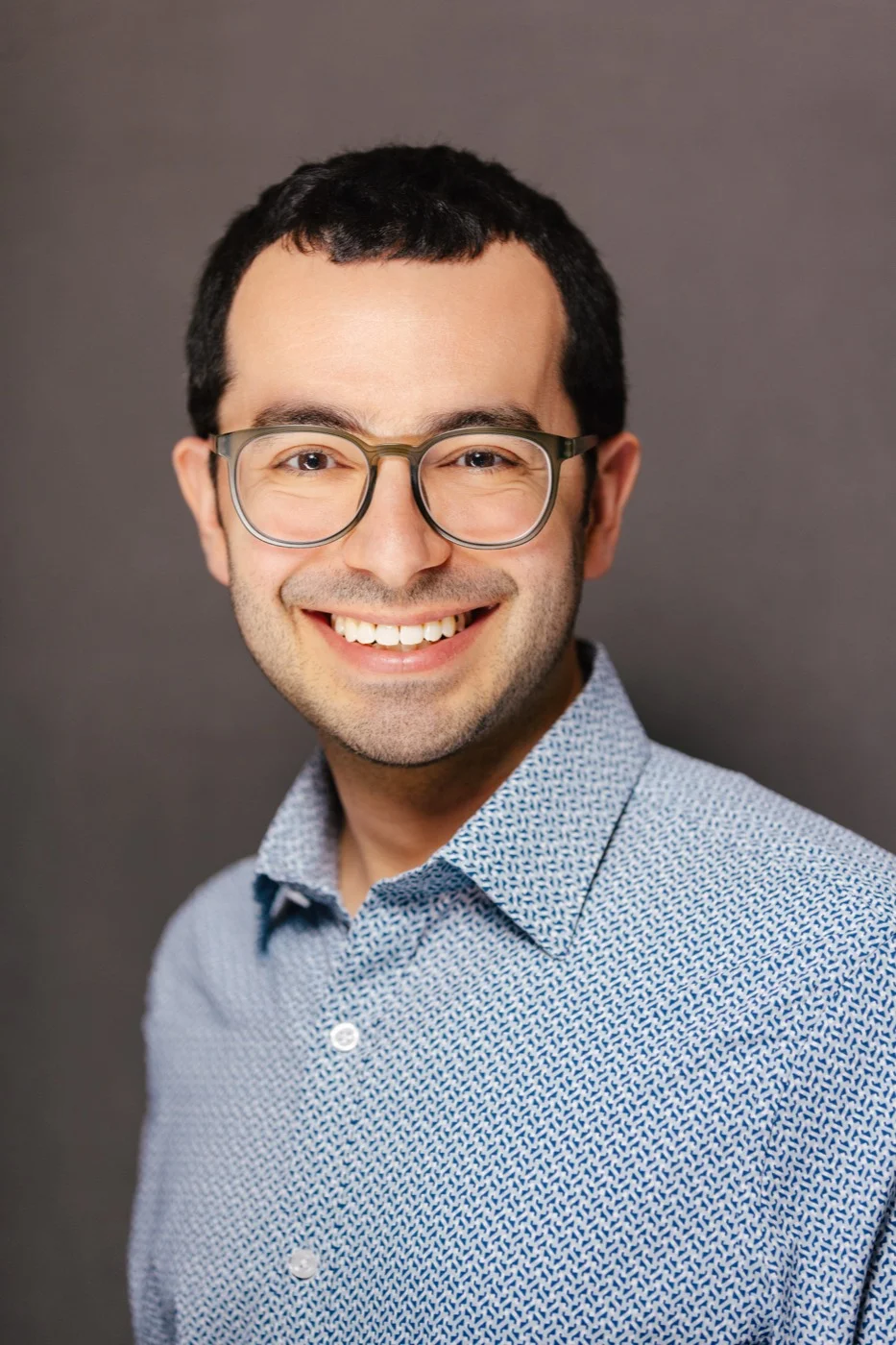 Businessman with glasses wearing a patterned blue shirt during a business portrait session