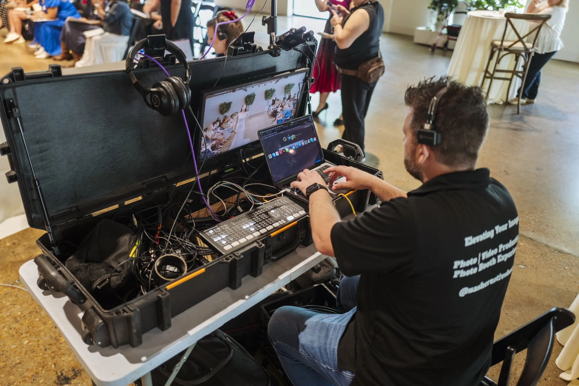 Production crew member operating a multi-camera switching station in front of a seated audience